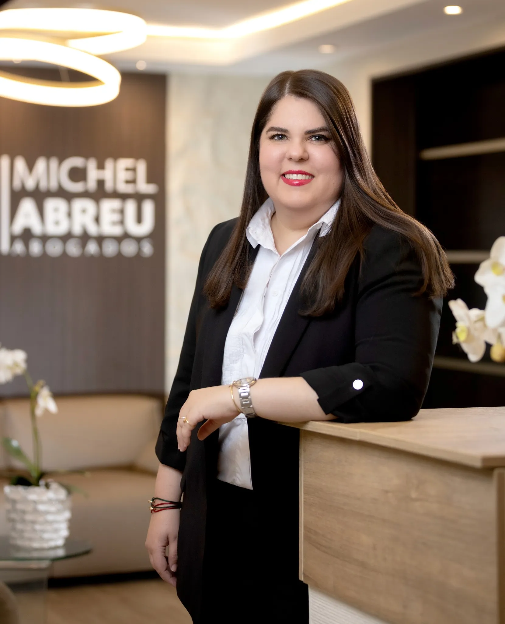 Smiling man with short dark hair in a blue blazer and black shirt against a neutral background, conveying a friendly and professional tone.